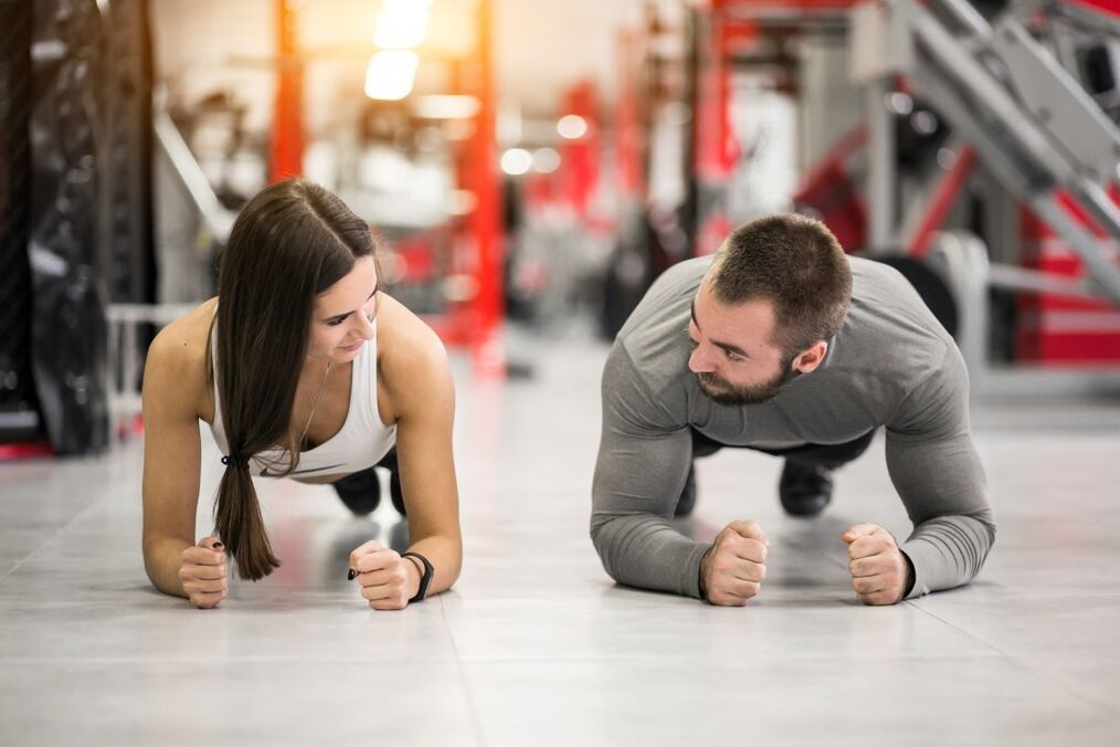 एक पुरुष और एक महिला सभी मांसपेशी समूहों के लिए डिज़ाइन किए गए प्लैंक व्यायाम करते हैं